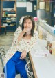 A woman sitting at a counter with a glass of water.